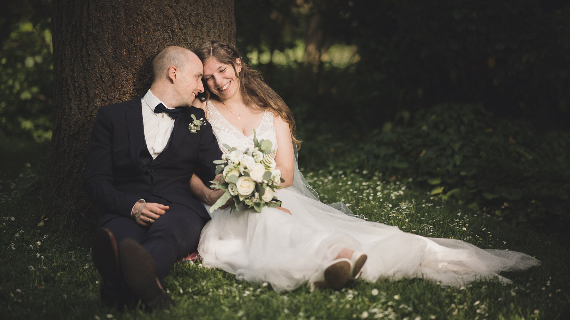 Hochzeitsfotograf Germersheim, Brautpaar sitzt romantisch am Baum im Park.