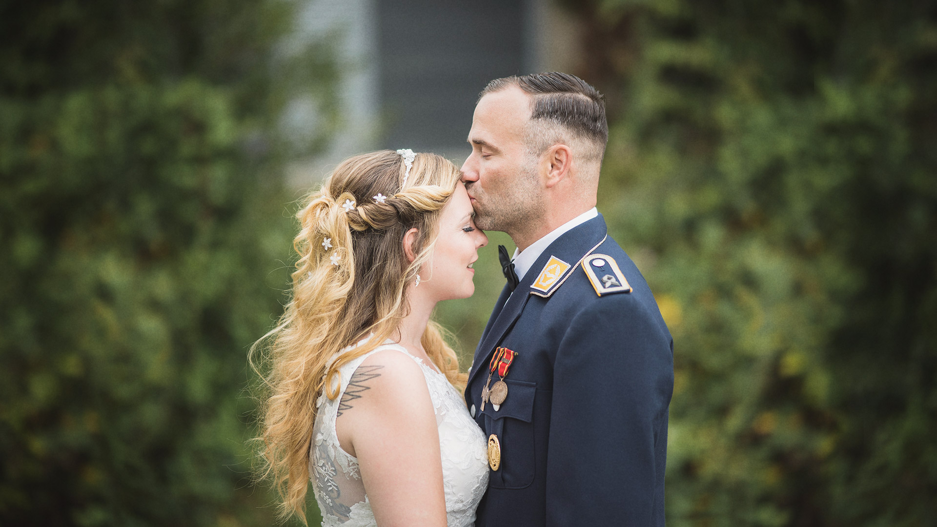 Bräutigam gibt der Braut einen Kuss auf dem Stirn